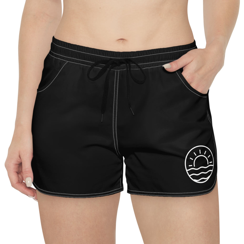 Aqua Sol Company black quick-dry coastal shorts with white contrast stitching, drawstring waist, and sunrise hem logo.